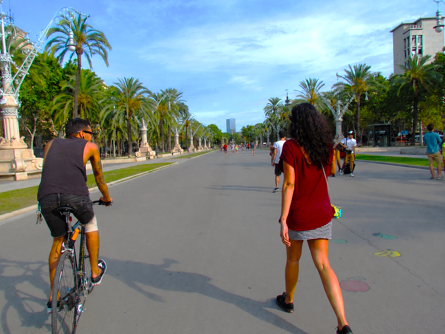 People cycling and walking on Passeig de Lluis Companys near Arc de Triomf.