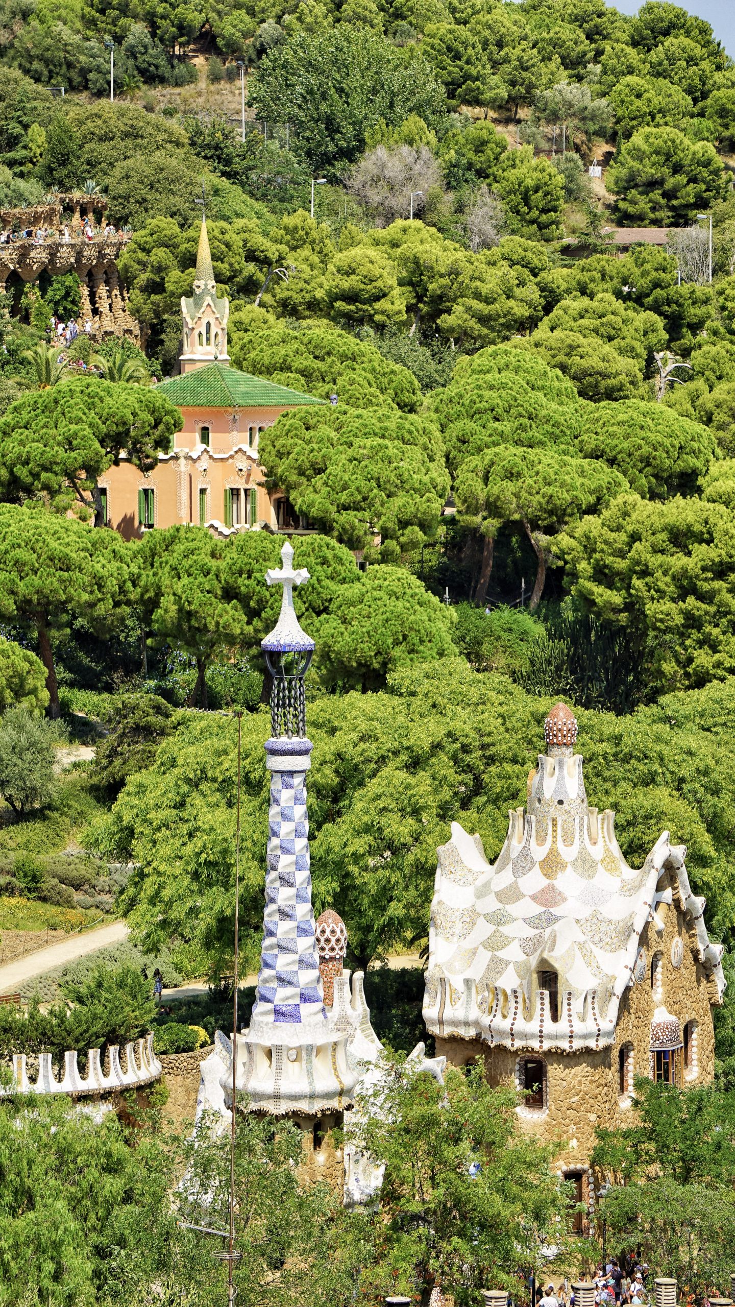 Park Guell gatehouse surrounded by trees on the hillside.