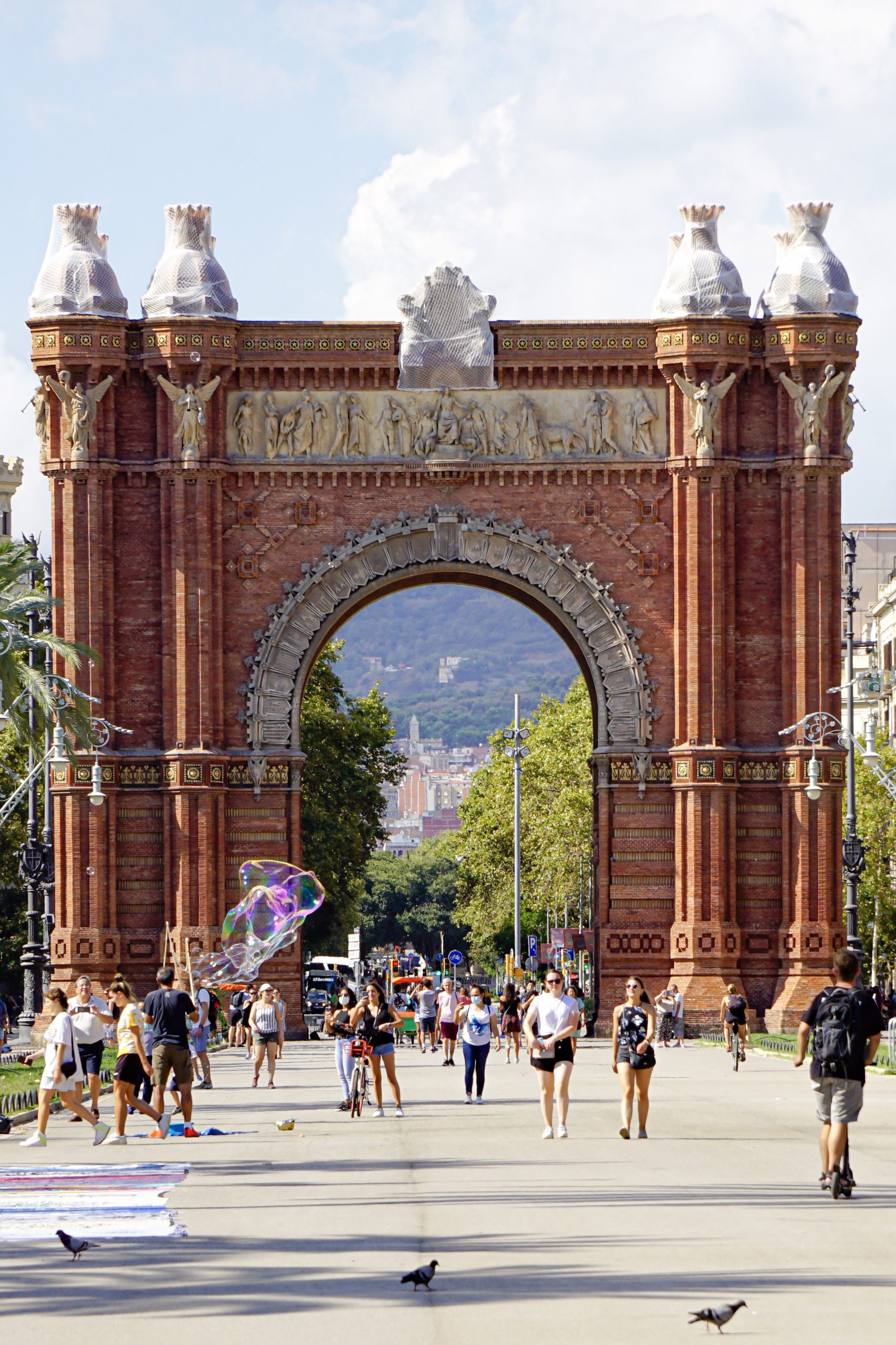 Arc de Triomf in Barcelona with people walking along Passeig de Lluis Companys.