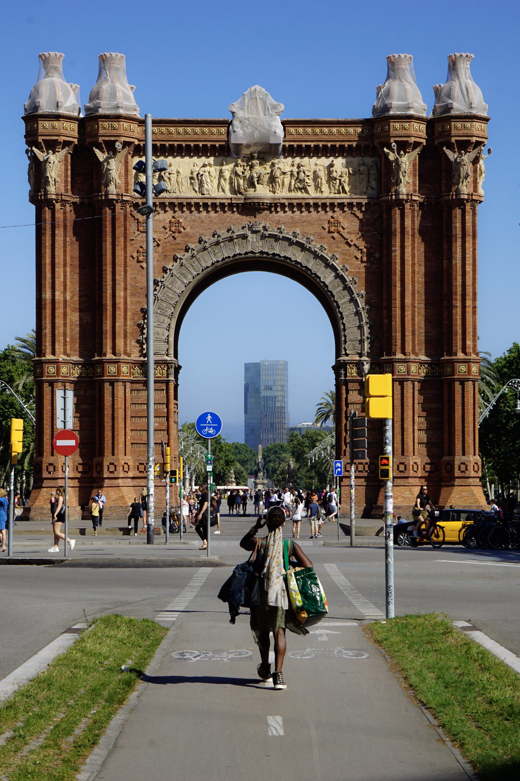 Close view of Arc de Triomf arch and brickwork under blue sky.