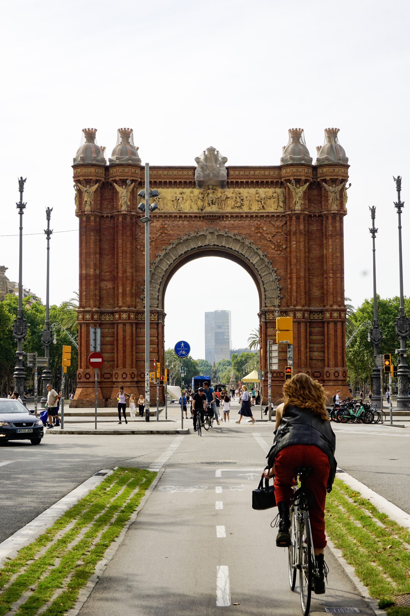 Cyclist approaching Arc de Triomf on a Barcelona bike lane.