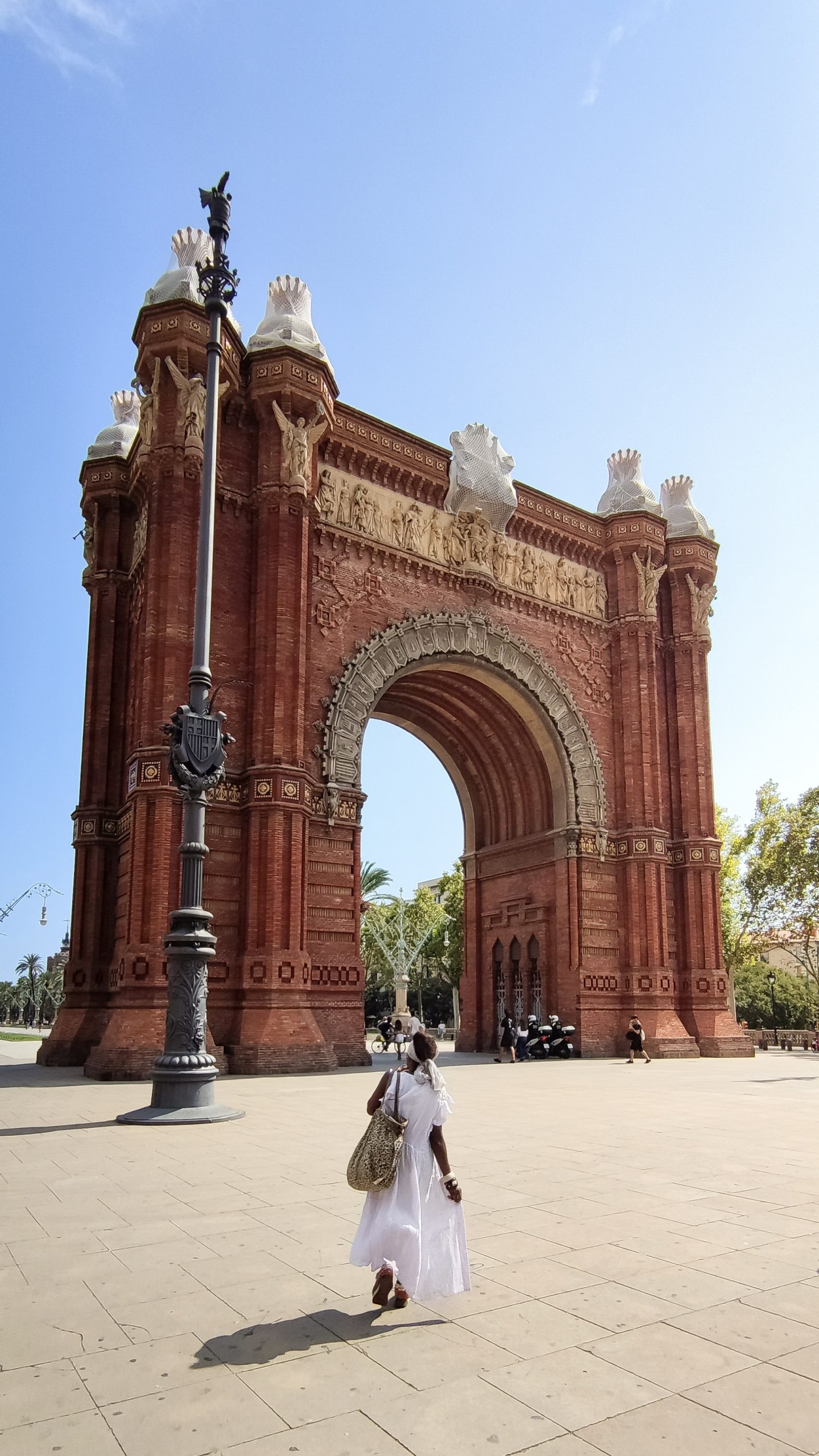 Person walking toward Arc de Triomf in Barcelona.