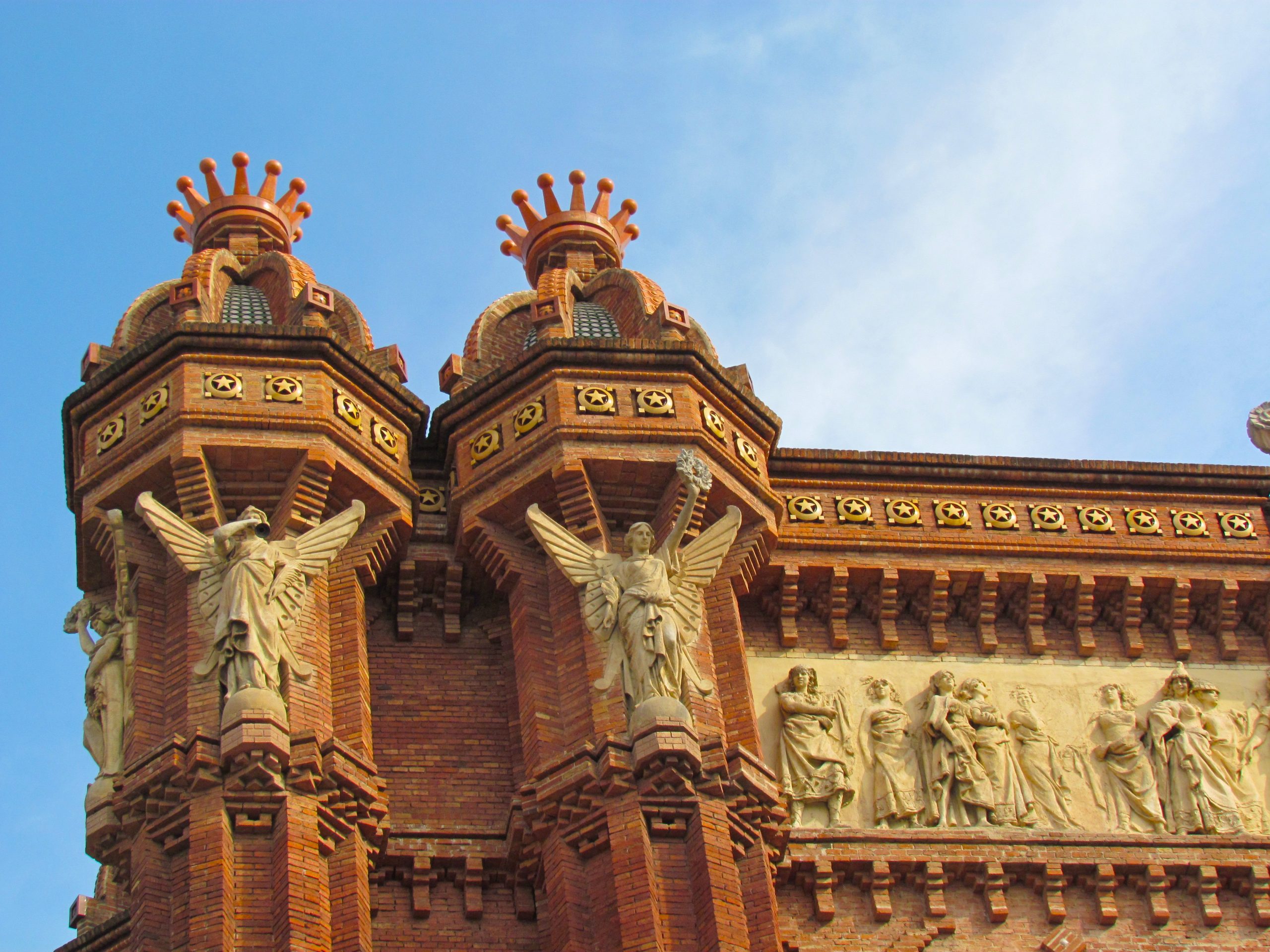 Red brick towers and sculptural frieze details on Arc de Triomf.