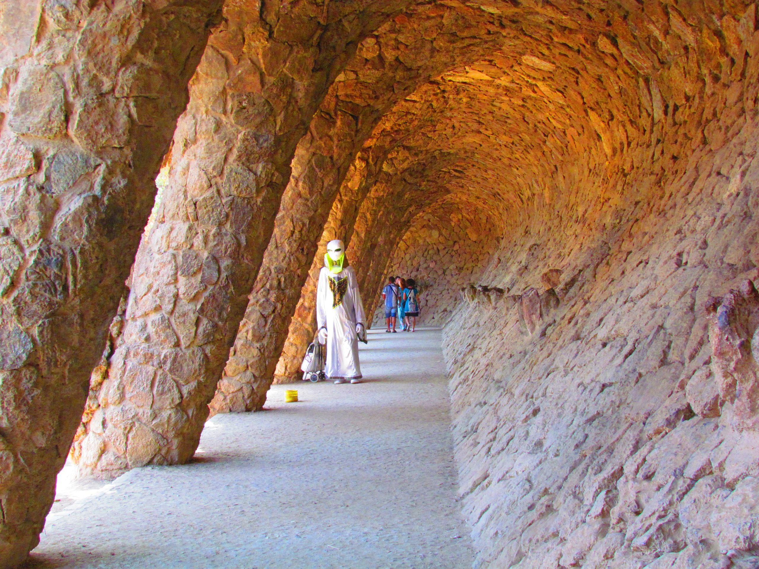 Stone tunnel and walkway under a Park Guell viaduct.