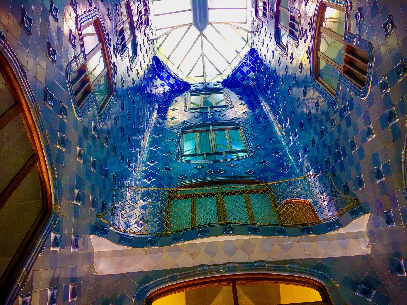 Blue tiled light well inside Casa Batllo looking upward.