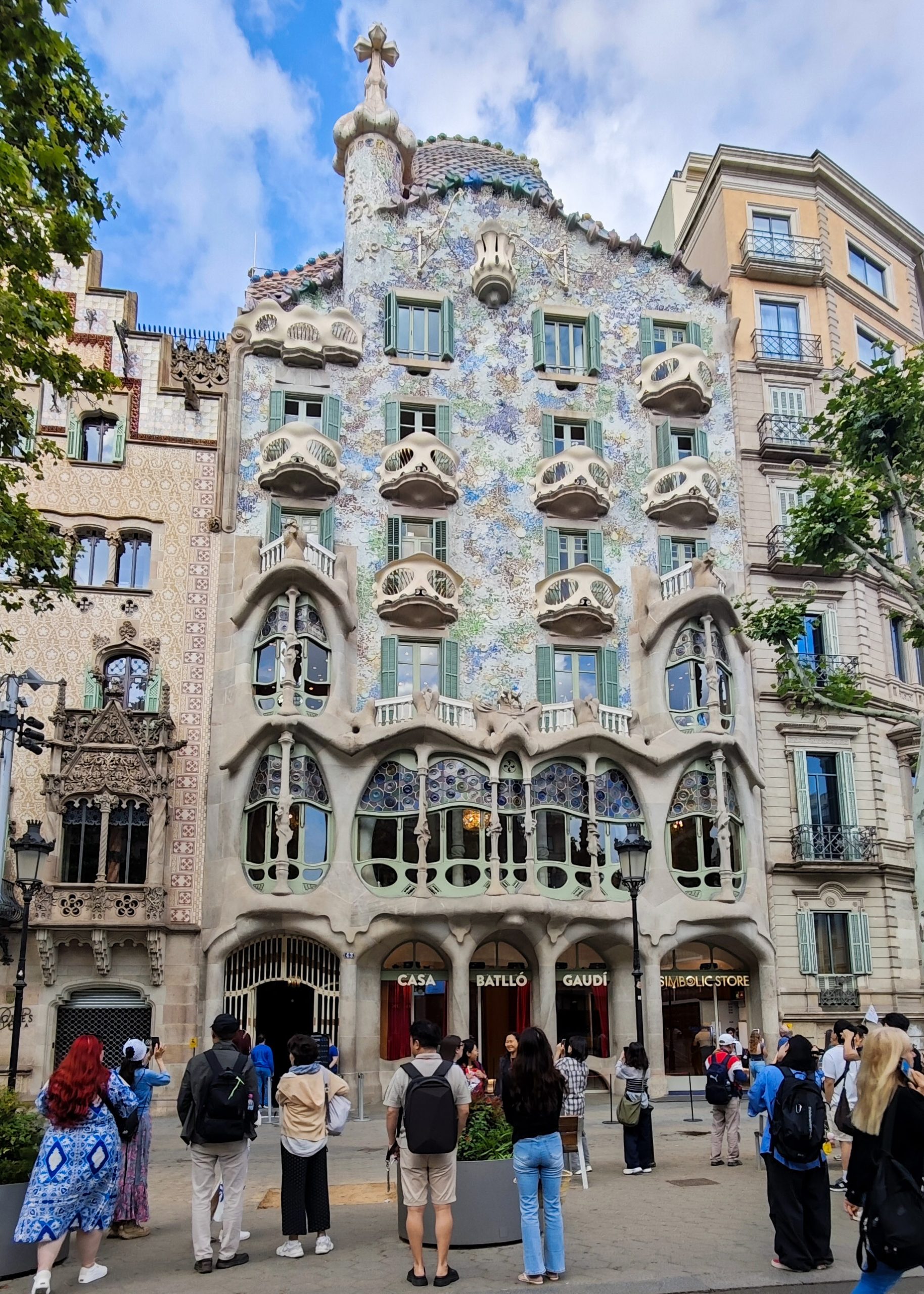 Casa Batllo facade on Passeig de Gracia with visitors outside.