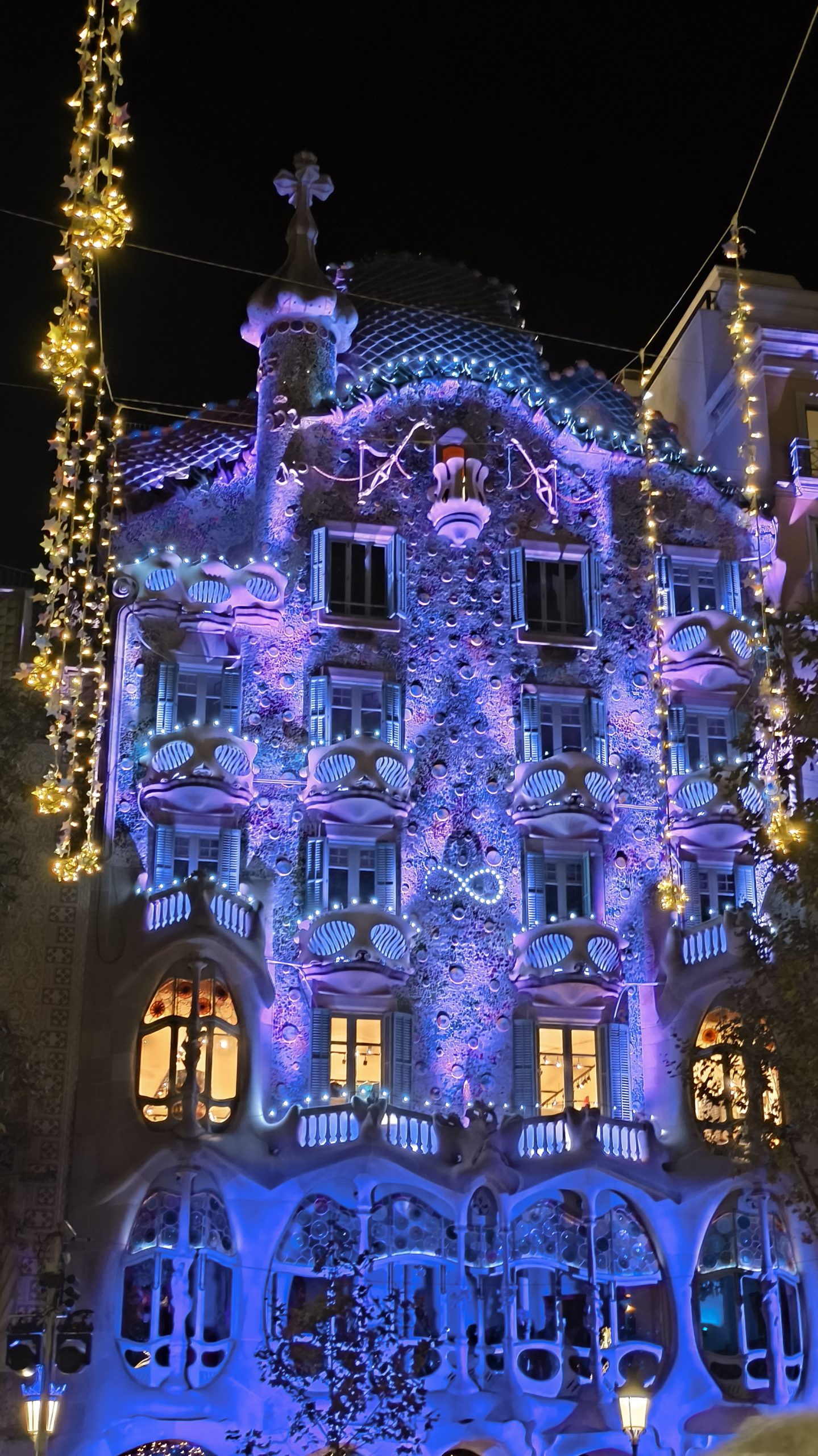 Casa Batllo illuminated at night with blue festive lights.